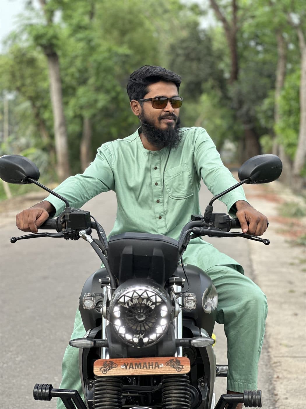 RH Razu riding along a tree-lined road