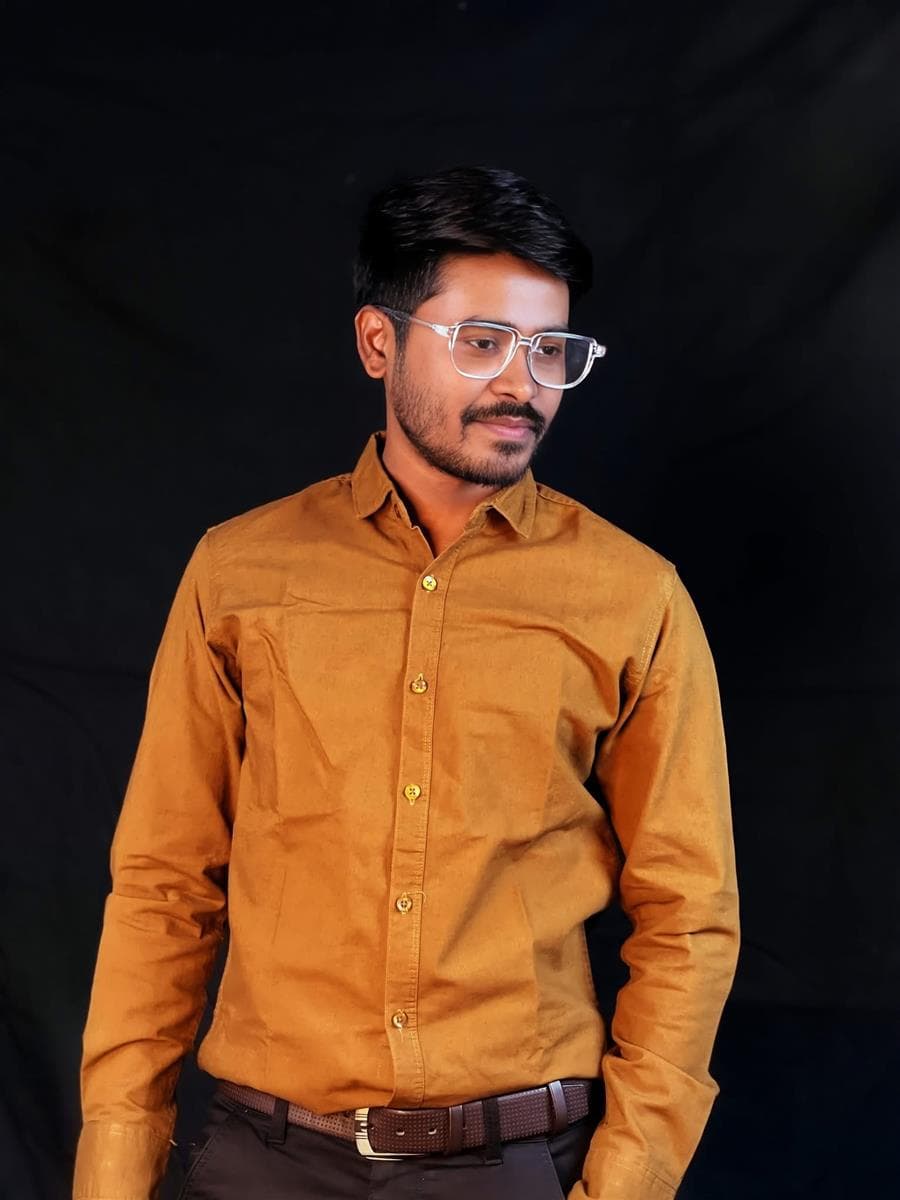 Studio portrait of RH Razu in a mustard shirt