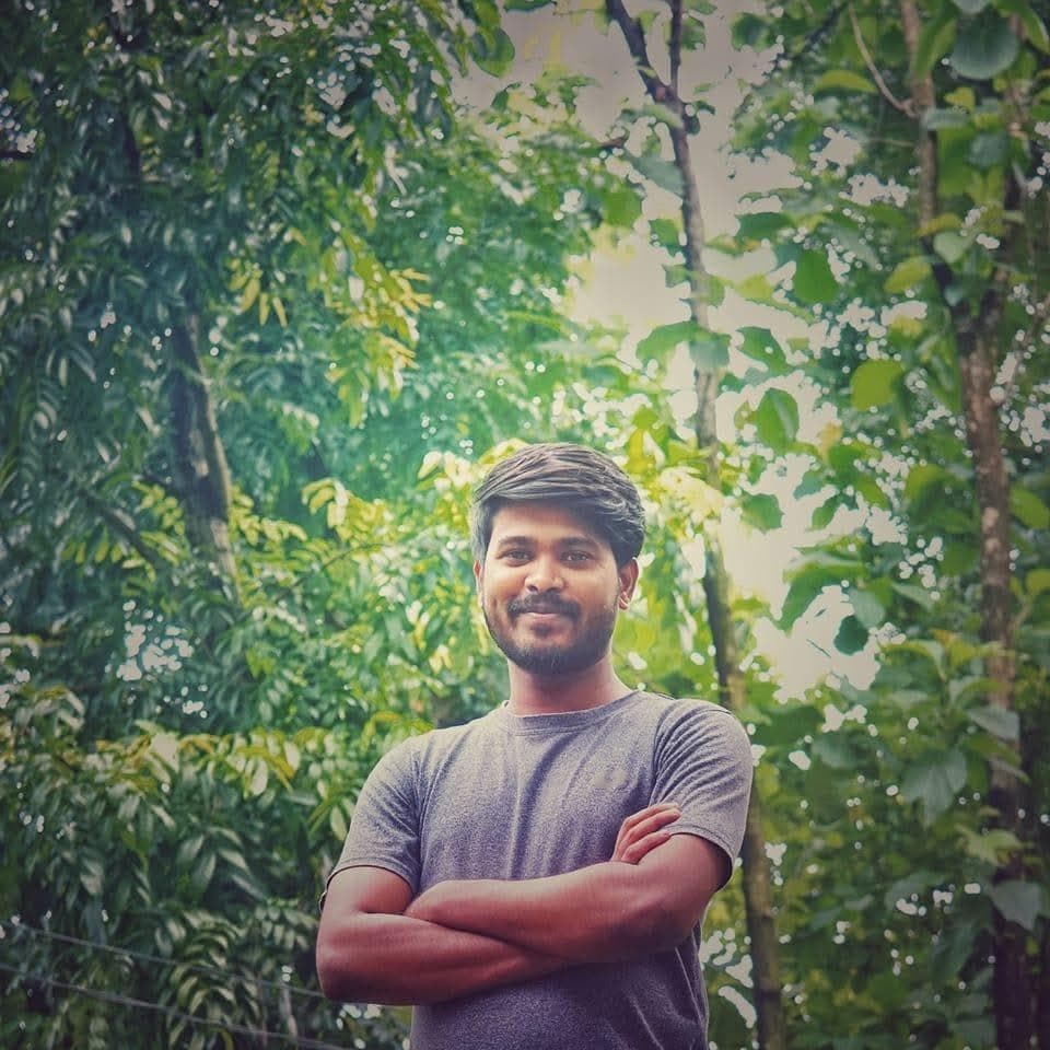 RH Razu standing among green trees